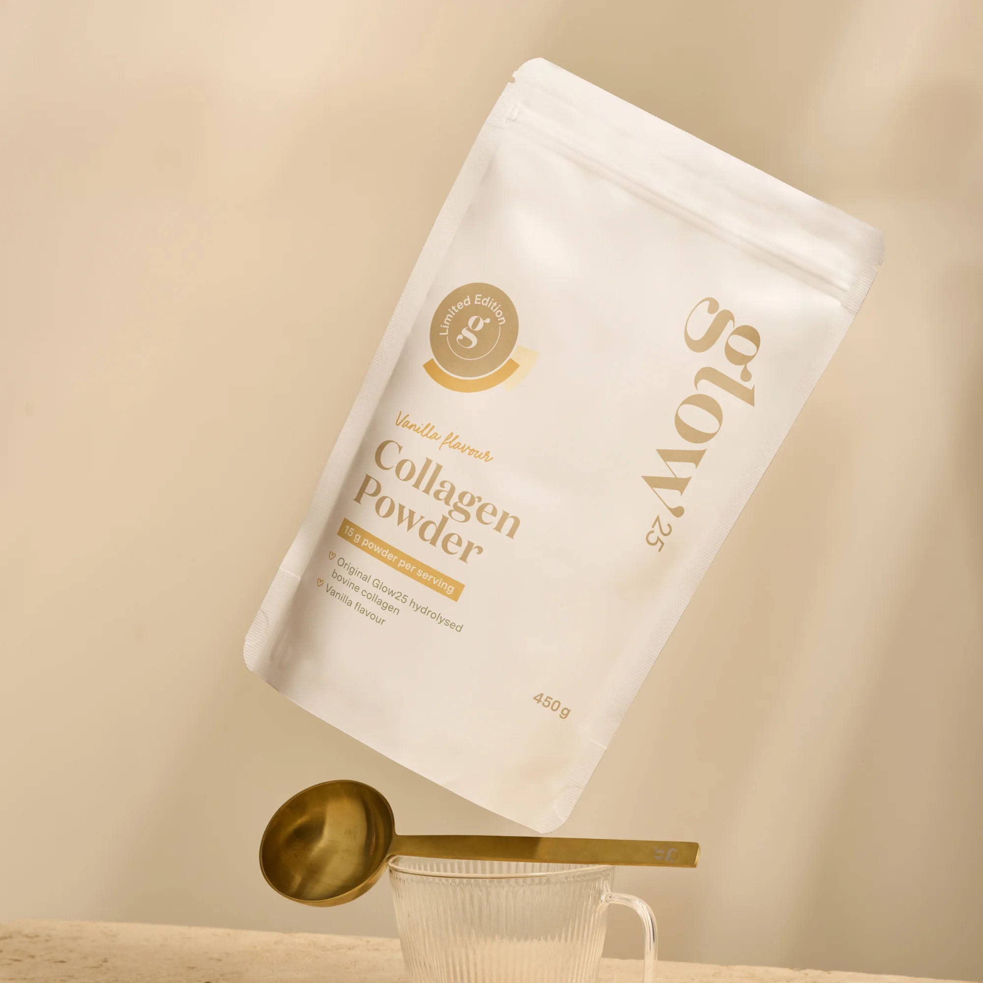 Glow25 Collageen Vanille verpakking op tafel met gouden lepel, luxe uitstraling en eenvoudig te doseren. 450 gram.
