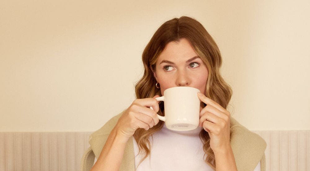Woman drinking the Glow25 collagen powder